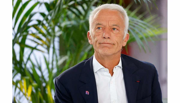 Patrick Martin debout devant un fond de verdure.