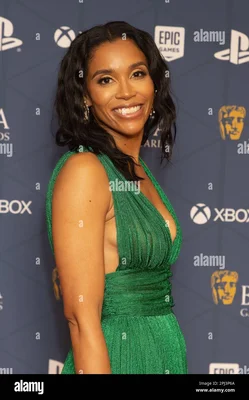Sarah Bond aux BAFTA Games Awards à Londres, en robe verte devant des logos de marques.