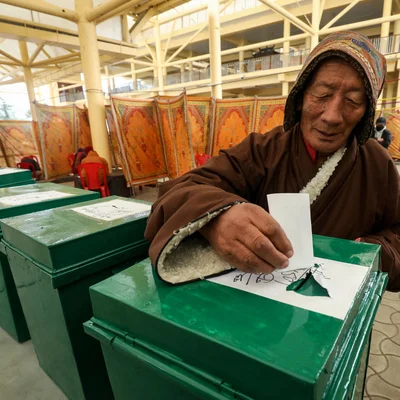 Un électeur de la diaspora tibétaine déposant son bulletin de vote dans une urne lors des élections du Parlement en exil.