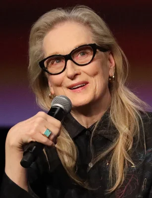 Meryl Streep avec un micro devant un fond violet
