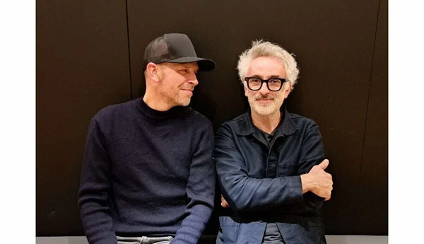 Vincent Delerm assis aux côtés d'un autre homme lors d'un événement.