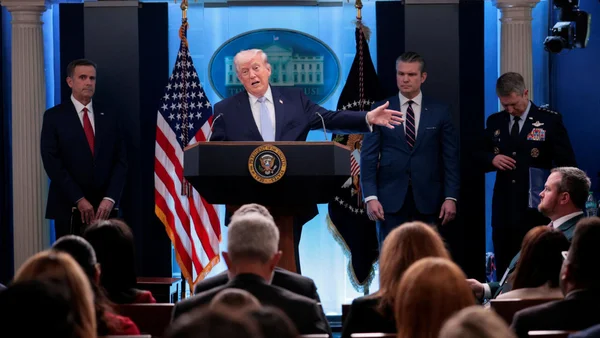 Donald Trump prononce une allocution ferme entouré de conseillers militaires.