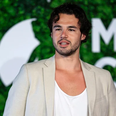 Anthony Colette posant en veste beige lors d'un événement.