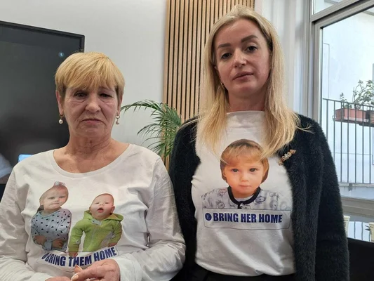 Darina et Liubov portant des photos d'enfants kidnappés sur leurs t-shirts.