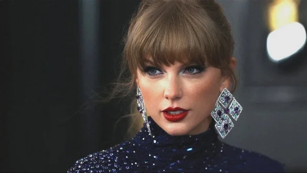 Portrait de Taylor Swift avec un maquillage bleu caractéristique.