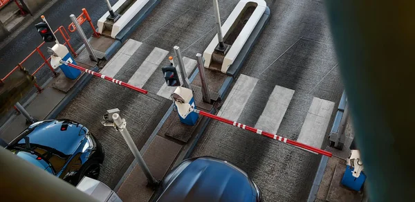 Gare de péage en Occitanie avec voitures circulant sous les panneaux de signalisation directionnels et panneaux électroniques.