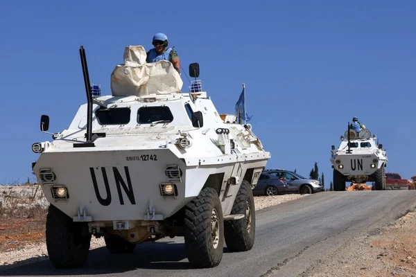 Convoye de blindés de la Finul en patrouille dans le Sud-Liban, soldats en tourelle, véhicules civils à proximité.