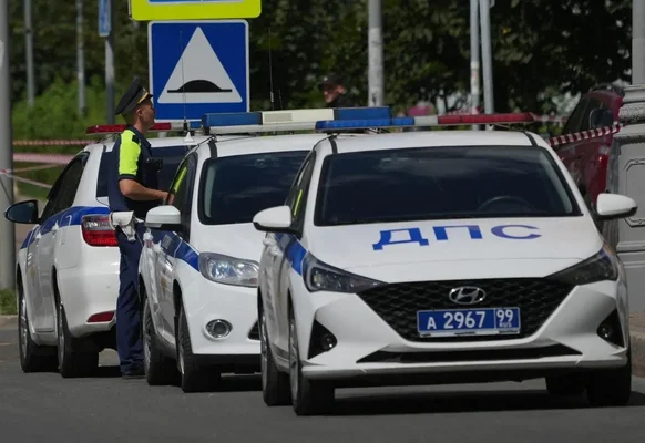 Un agent de police russe et des véhicules de patrouille ДПС.
