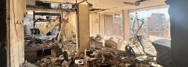 Intérieur dévasté d'un immeuble bombardé à Beyrouth, avec des débris et des murs effondrés.