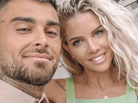 Jessica Thivenin et Thibault Garcia enlacés devant un décor de verdure tropicale.