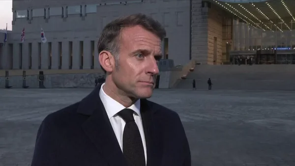 Emmanuel Macron devant un bâtiment officiel lors d'une déclaration en extérieur.