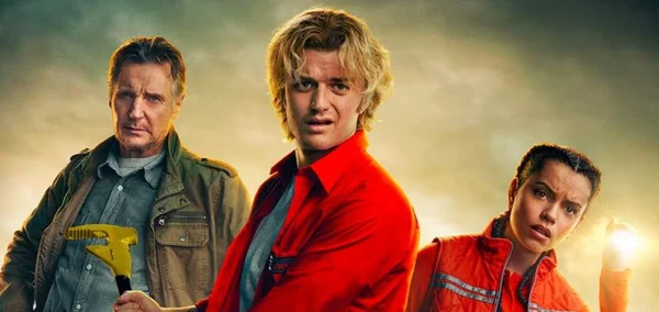 Scène du film avec Joe Keery (veste verte), un acteur en chemise rouge et Georgina Campbell (gilet orange) sous un ciel menaçant.