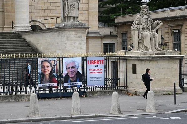 Affiche de soutien demandant la libération de Cécile Kohler et Jacques Paris apposée sur une grille.