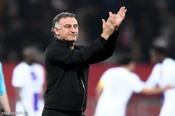 Christophe Galtier sur le bord d'un terrain, en tenue d'entraînement Puma rouge.