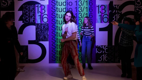 Une jeune personne posant dans le cadre coloré et graphique du Studio 13/16 à la Gaîté Lyrique.