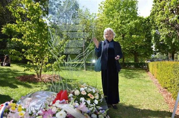 Une femme se recueillant devant la première stèle européenne dédiée aux victimes de l'agent orange inaugurée en France.