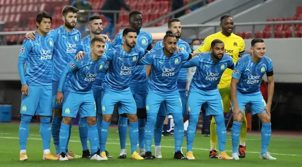 Une équipe de football posant pour une photo officielle sur la pelouse d'un stade.