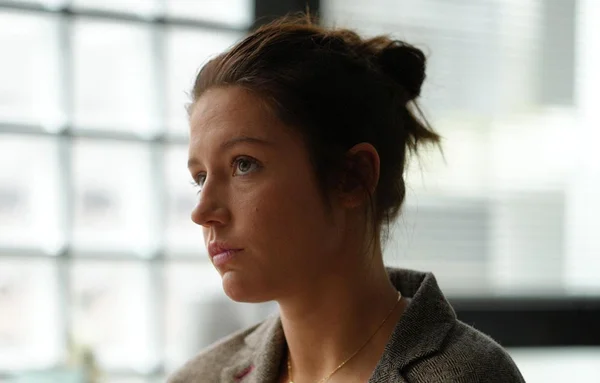 Adèle Exarchopoulos en veste grise, photographiée de profil au naturel.