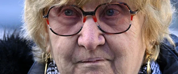 Portrait rapproché de Jacqueline Jacob portant des lunettes à accents rouges.