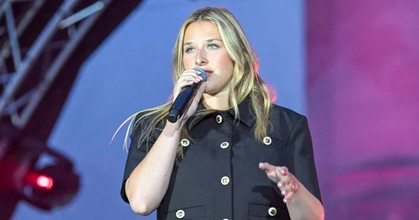 Héléna Bailly chantant lors d'un concert tout en évoquant les rumeurs concernant Pierre Garnier.