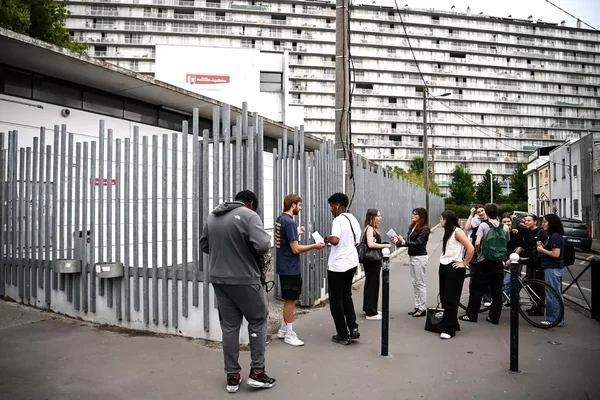 Parents et élèves rassemblés devant l'entrée du collège.