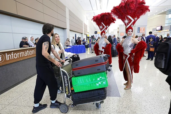 Célébration dans un terminal d'aéroport avec des showgirls pour le lancement du service Air France vers Las Vegas.