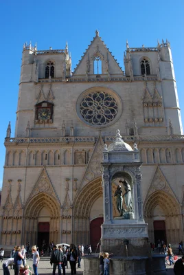 Façade d'une cathédrale avec une rosée centrale et une horloge.