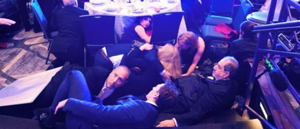 Journalistes et officiels, dont Mélania Trump, se protégeant au sol lors de l'attaque.