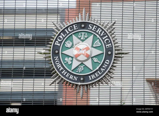 Le logo du Service de police d'Irlande du Nord (PSNI) apposé sur une grille métallique.