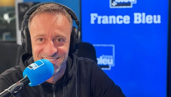 Difool en entrevue sur France Bleu, avec un casque audio et un sweat à capuche noir.