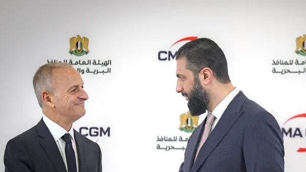 Deux hommes en costume en conversation lors d'une réunion officielle à Paris.