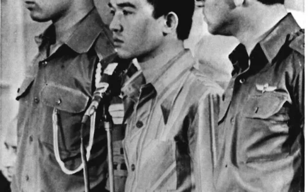 Trois hommes en uniforme devant un micro lors d'une déclaration historique.