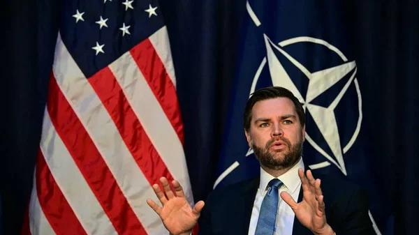 JD Vance saluant la foule dans un cadre diplomatique officiel.