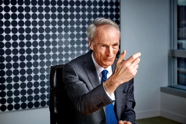 Jean-Dominique Senard assis dans son bureau, illustrant son propos d'un geste de la main.
