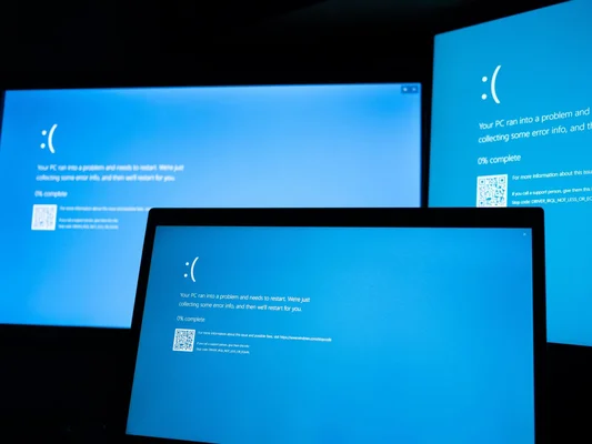 Trois écrans affichant l'écran bleu de la mort de Windows, illustrant les plantages de logiciels Microsoft dans l'espace.