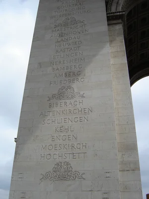 Détail gravé de noms de villes et blasons sur l'Arc de Triomphe à Paris.