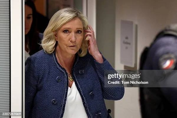 Louis Aliot et Jordan Bardella entourés de membres du Rassemblement national lors d'un rassemblement du parti.