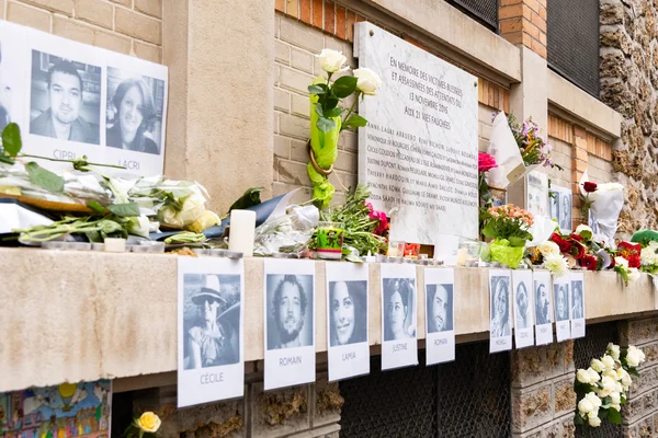 Mémorial improvisé avec photos des victimes, fleurs et bougies lors des commémorations du 13 novembre à Paris.