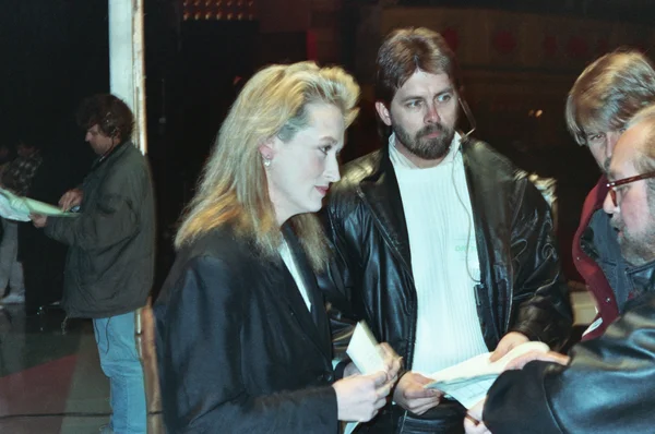 Meryl Streep lors des Grammy Awards 1990, en discussion backstage avec un homme en veste de cuir.