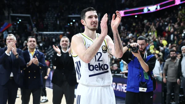 Un joueur en action sur le terrain portant le maillot numéro 12.