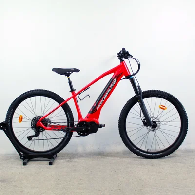 Le VTT électrique Nakamura ESummit 740 en version rouge exposé sur un support.