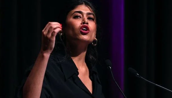 Rima Hassan s'exprimant au micro lors d'un meeting de campagne aux élections européennes 2024.