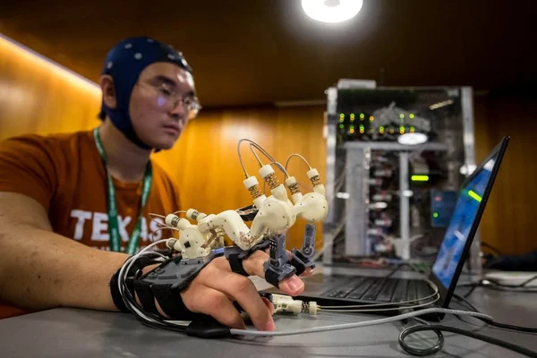 Utilisation d'un gant robotique piloté par une interface cerveau-ordinateur.