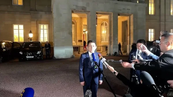 Déclaration à la presse la nuit devant un bâtiment lors de négociations.