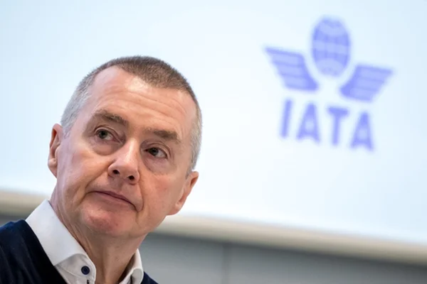 Un dirigeant posant devant un fond aux couleurs de l'IATA.