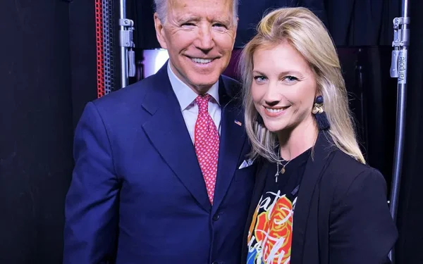 Audrey Lefèvre sourit à côté d'un homme en costume bleu et cravate rouge.