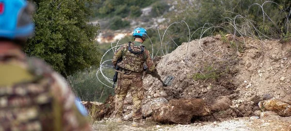 Soldat de la Finul posté près de barbelés dans une zone rocailleuse du Sud-Liban, après que la force a été prise pour cible.
