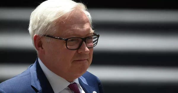 Le vice-ministre russe des Affaires étrangères en visite à Cuba, portant un costume bleu et une cravate violette.