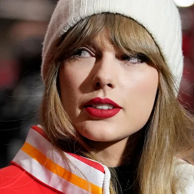 Taylor Swift vêtue d'une robe scintillante bleue et or.