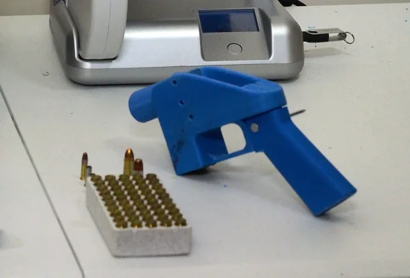Un pistolet en plastique bleu fabriqué par impression 3D avec des munitions, illustrant le phénomène des armes fantômes.